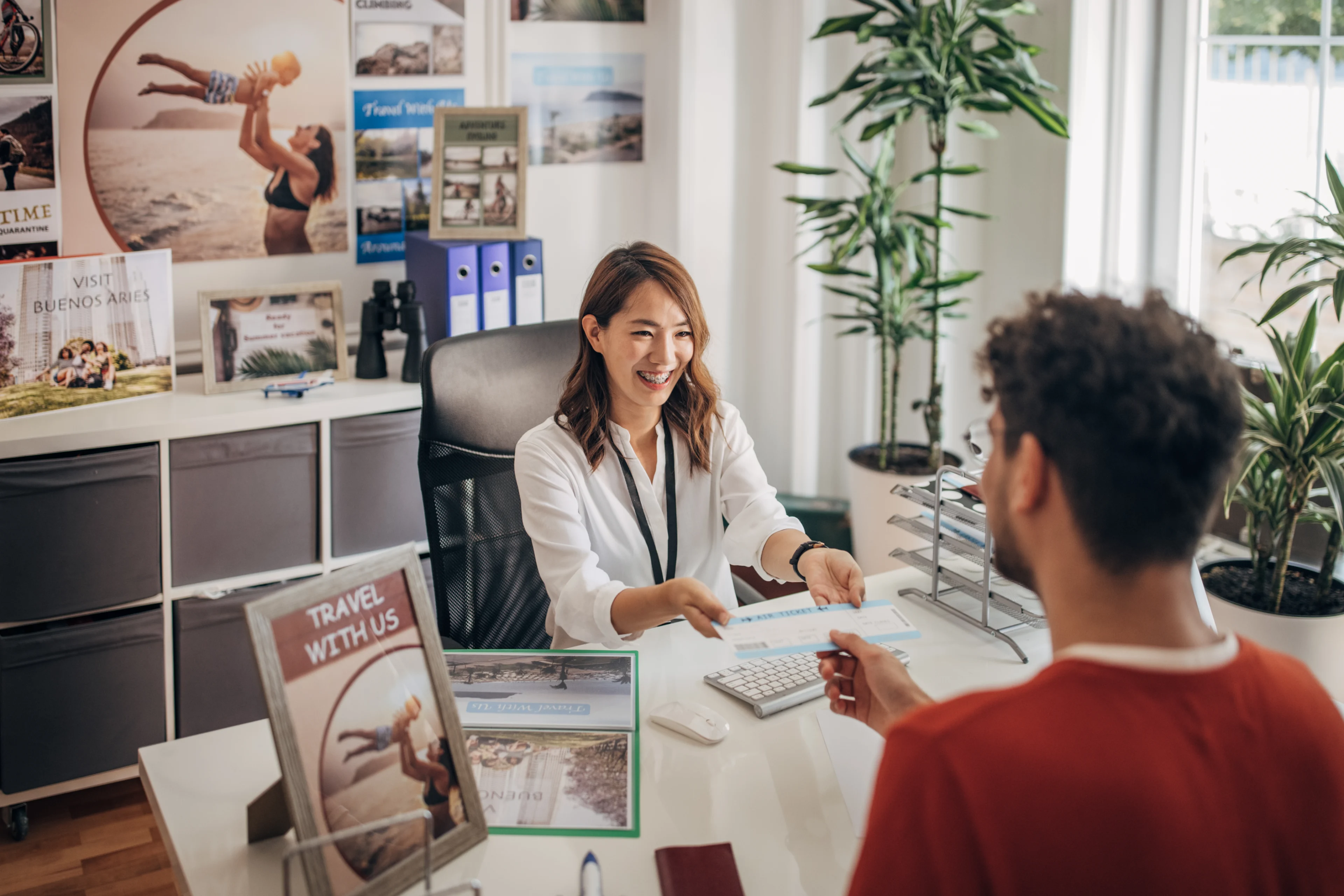 Travel agent assisting a client in office.